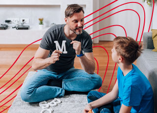 Speech-language pathologist working with a child during a learning activity on the floor.