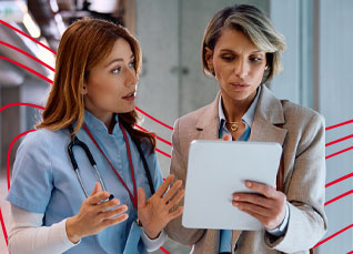Healthcare leader and clinician reviewing a file together in a hospital hallway.