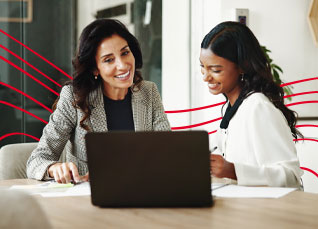Two professionals reviewing financial information together on a laptop at a table.