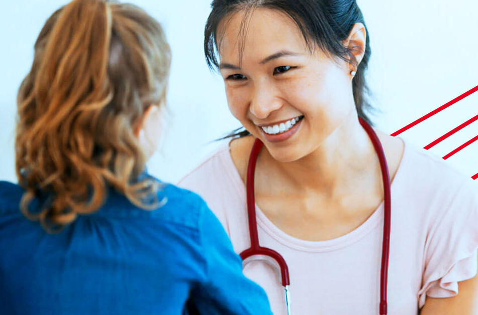 A woman wearing a stethoscope smiles at a child patient.