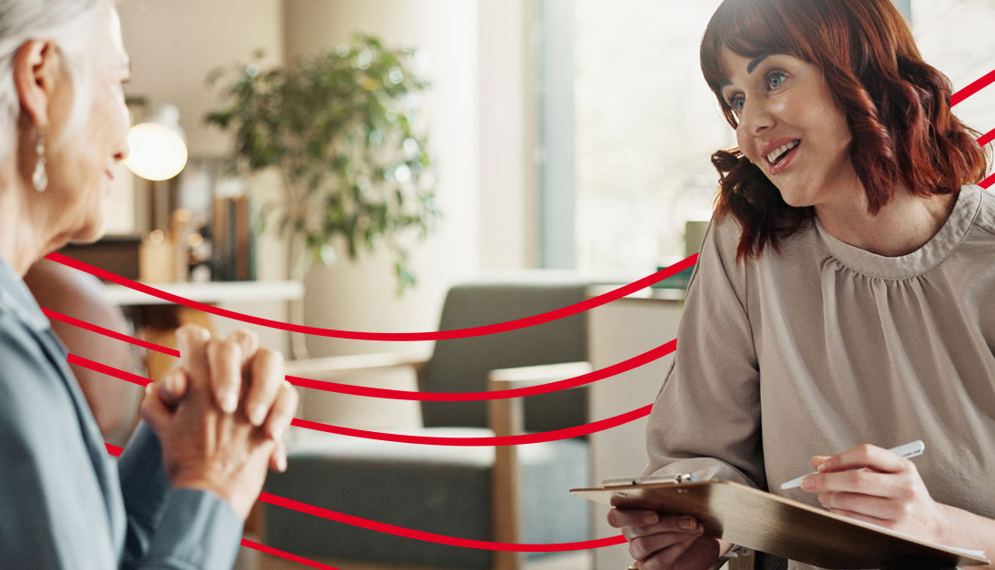 A patient speaks with a therapist in an office setting.