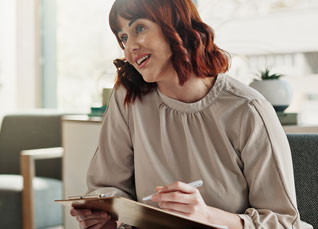 A patient speaks with a therapist in an office setting.