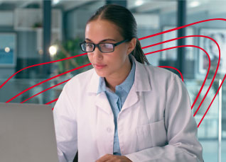 Clinical researcher reviewing data on a laptop in a laboratory environment.