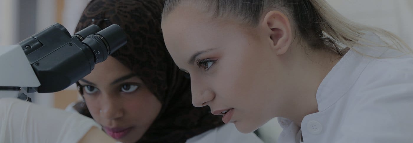 Medical Laboratory Sciences students examining with a microscope.