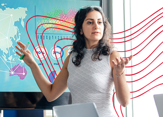 Woman presenting data in front of a digital world map and analytics screen, gesturing as she explains geographic insights.