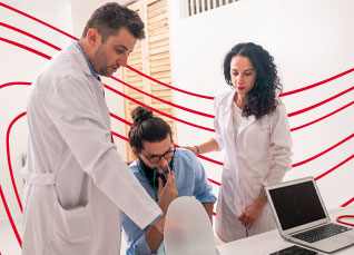 Healthcare professionals in lab coats reviewing patient information together in a clinical setting.