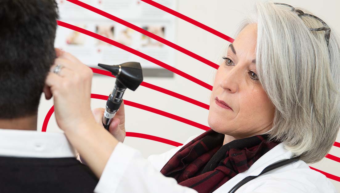 Nurse practitioner examining patient’s ear in clinical setting.