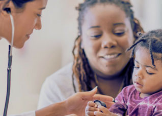 Nurse examining a child held by parent in a clinic.