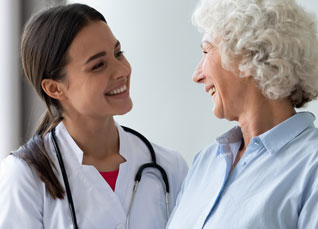 Nurse practitioner performing a checkup with a stethoscope on an older female patient during a routine wellness visit in a clinic.