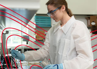 Laboratory scientist conducting testing with glassware and equipment in a research facility.
