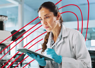Laboratory scientist analyzing data on a tablet beside a microscope in a research lab.