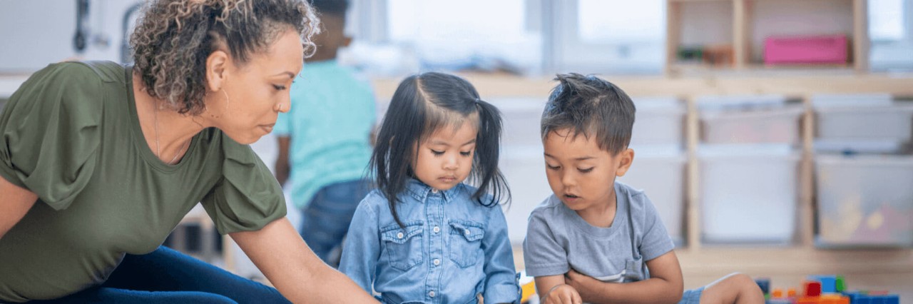 Early childhood education instructor teaching two children.