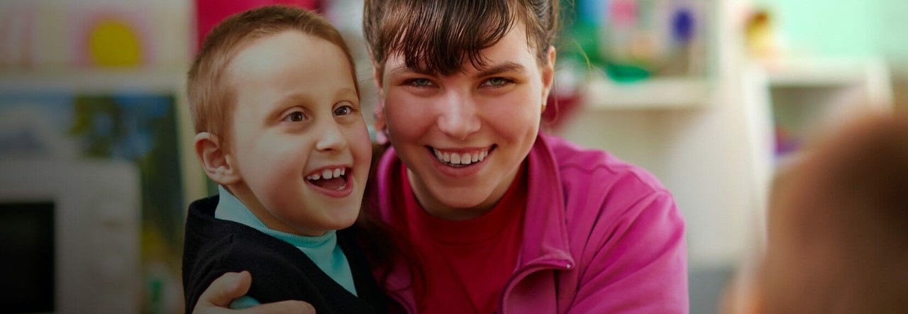 A special education teacher interacting with a young student.