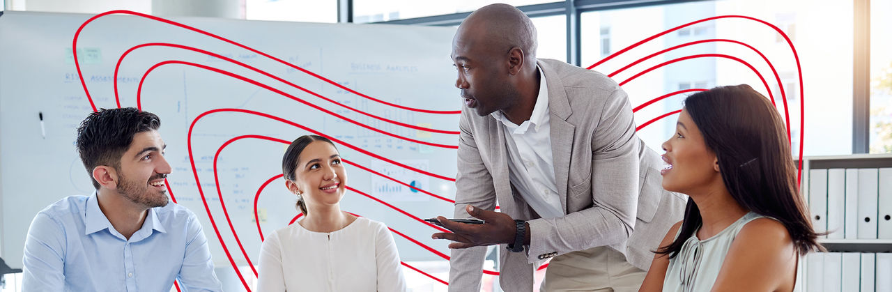 A business analytics professional leads a discussion with colleagues, reviewing data and insights during a collaborative meeting.