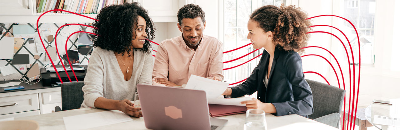 A small group reviews tax documents together at a table, collaborating on financial and tax planning decisions.