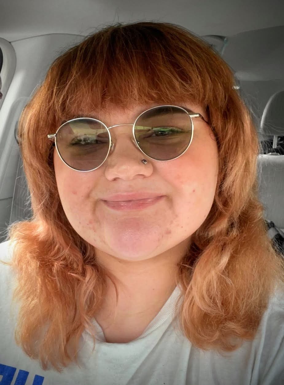 UC BA Communication student Cedar taking a selfie while wearing sunglasses.