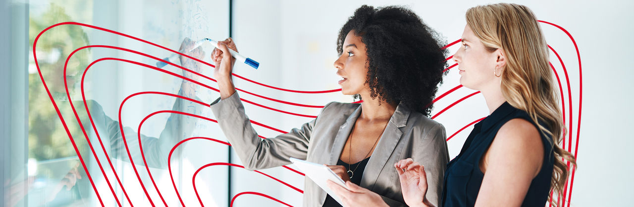 Two professionals analyze data together on a laptop, reviewing financial information in a modern office setting.