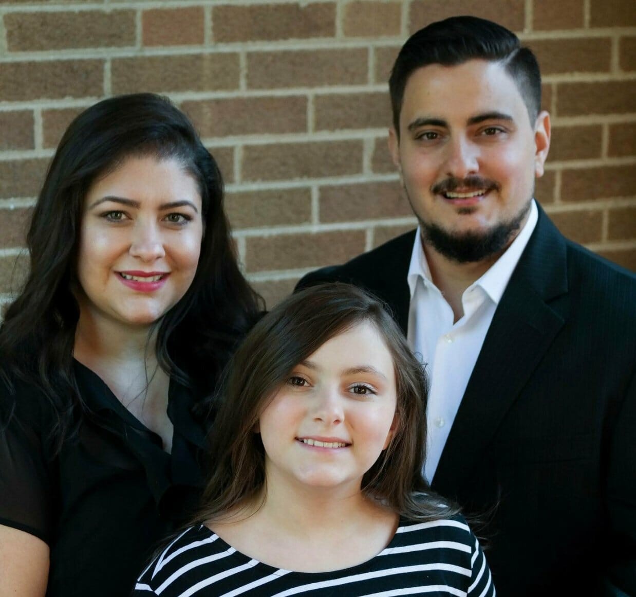 Portrait of UC social work student Ana B. with her husband and daughter.