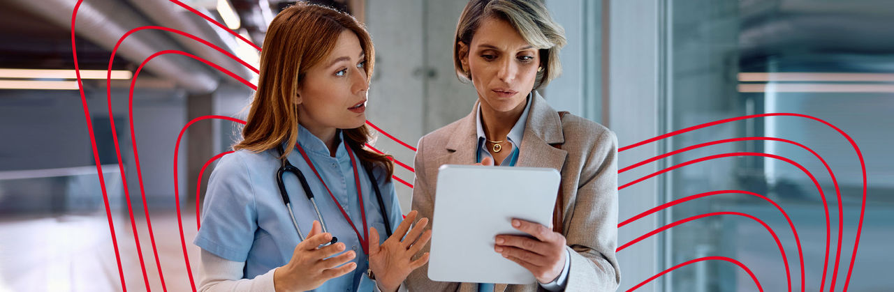 Six health professionals sit around a wooden table during a meeting.