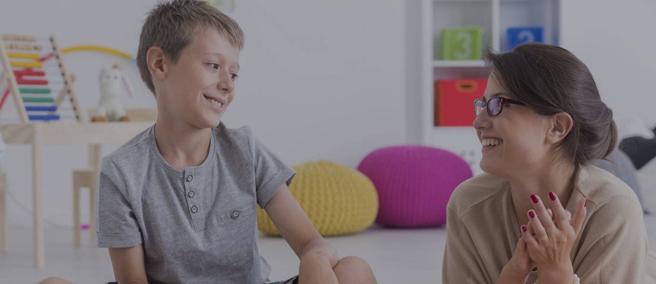 Behavior analyst engaging with a child in classroom setting.