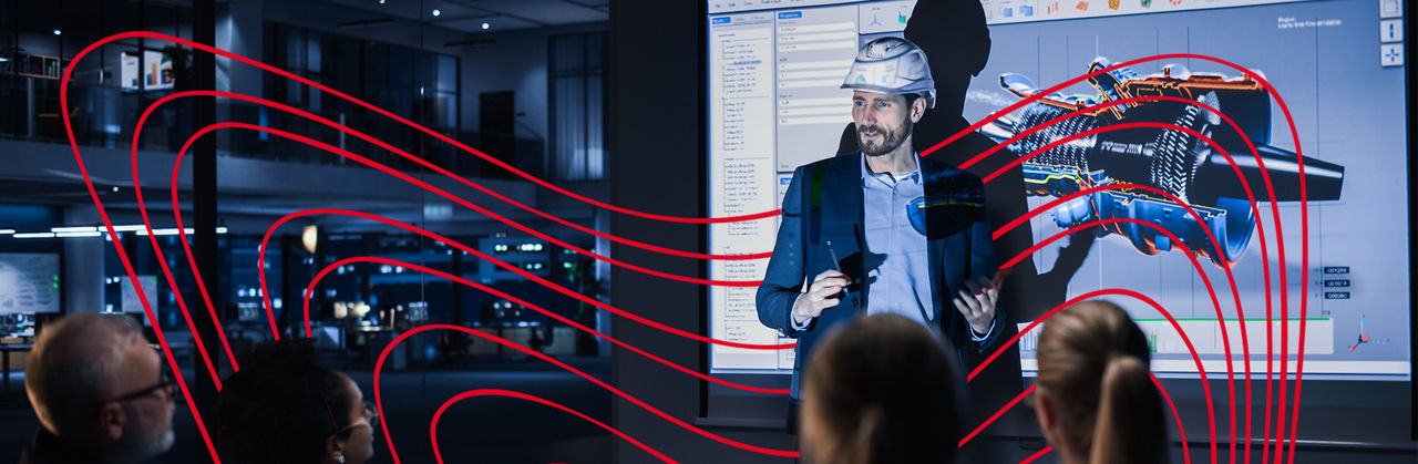 Man wearing hard hat presenting to group of people on engineering design