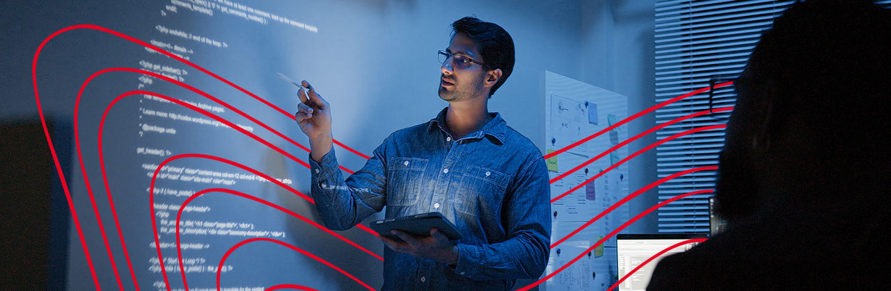 Man with tablet presenting computer programming code to group