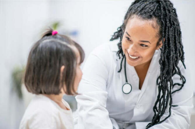 A nurse interacts with a child patient.