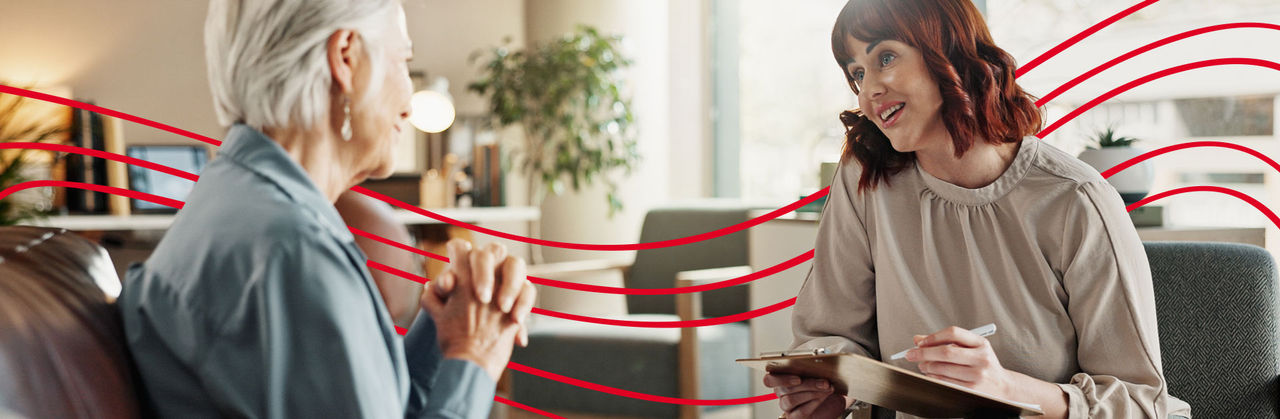 A patient speaks with a therapist in an office setting.