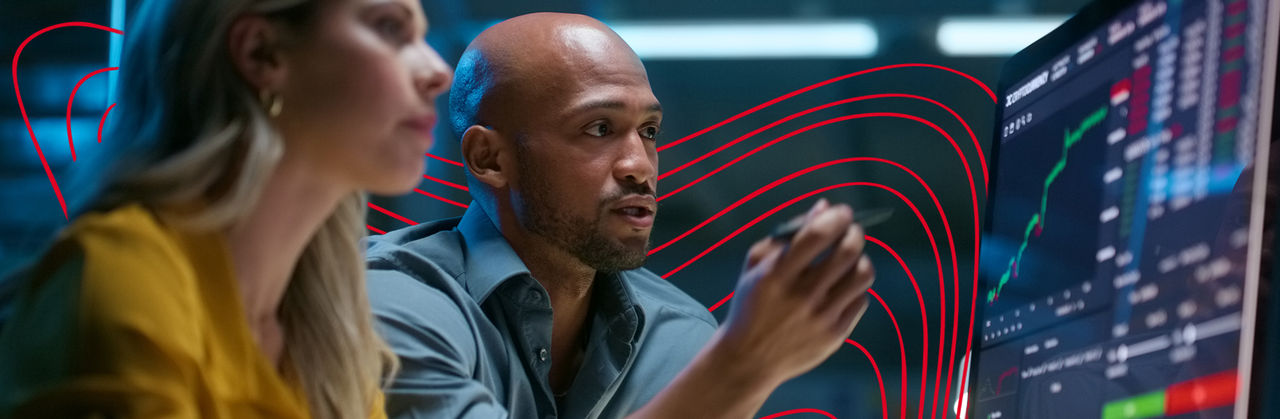 Two professionals analyze financial data on a large digital screen, discussing market trends and quantitative insights.